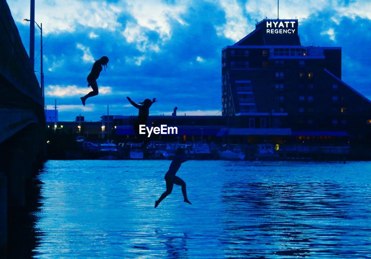 SILHOUETTE OF MAN JUMPING IN SWIMMING POOL