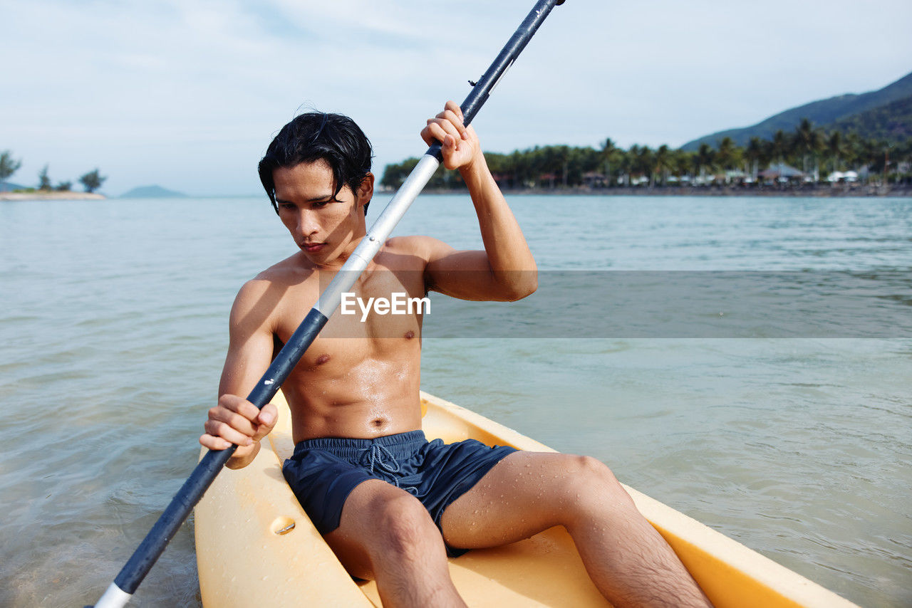 low section of man kayaking in lake