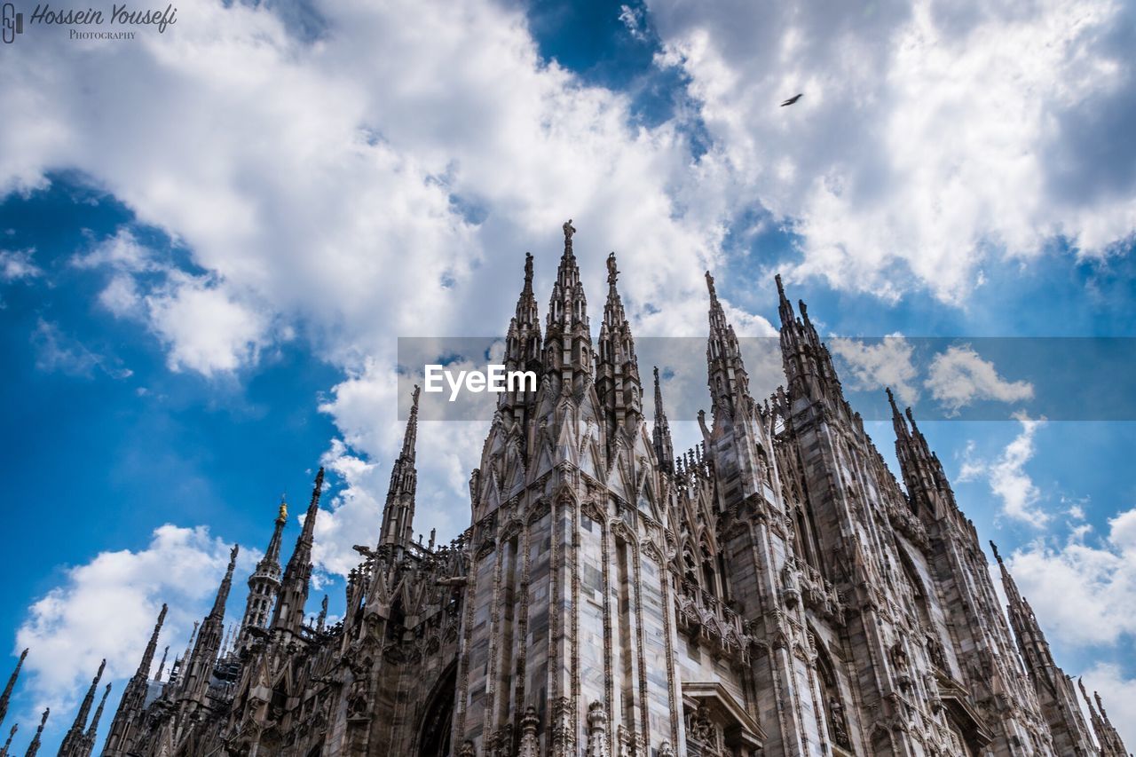 Low angle view of milan cathedral against cloudy sky