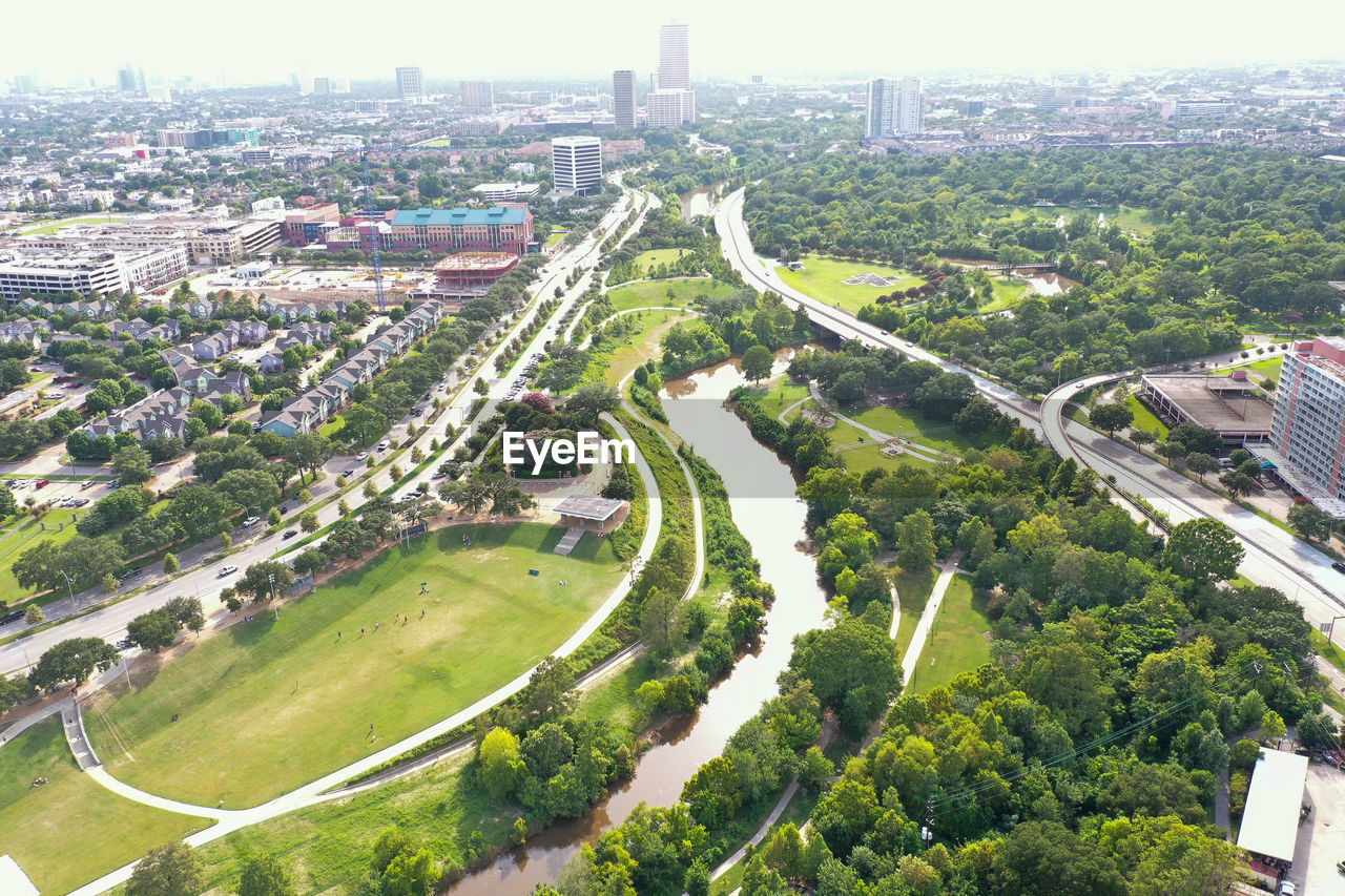 HIGH ANGLE VIEW OF ROAD BY BUILDINGS IN CITY