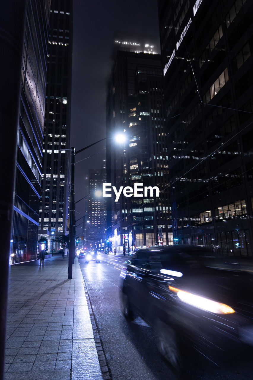 VIEW OF CITY STREET AND BUILDINGS AT NIGHT