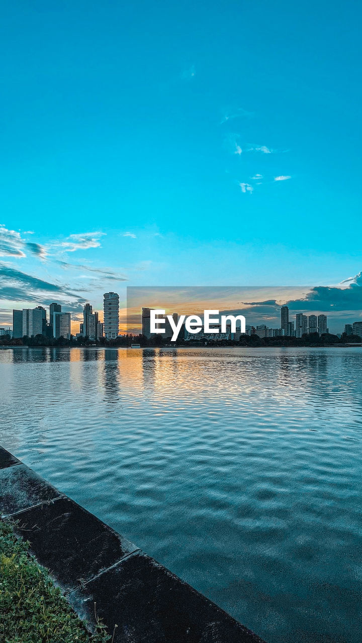 SEA AND BUILDINGS IN CITY AGAINST SKY