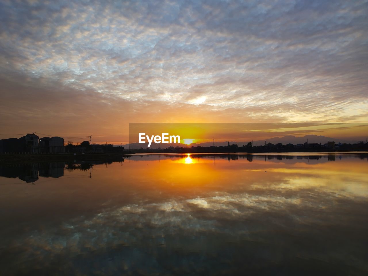 SCENIC VIEW OF LAKE AGAINST ORANGE SKY DURING SUNSET