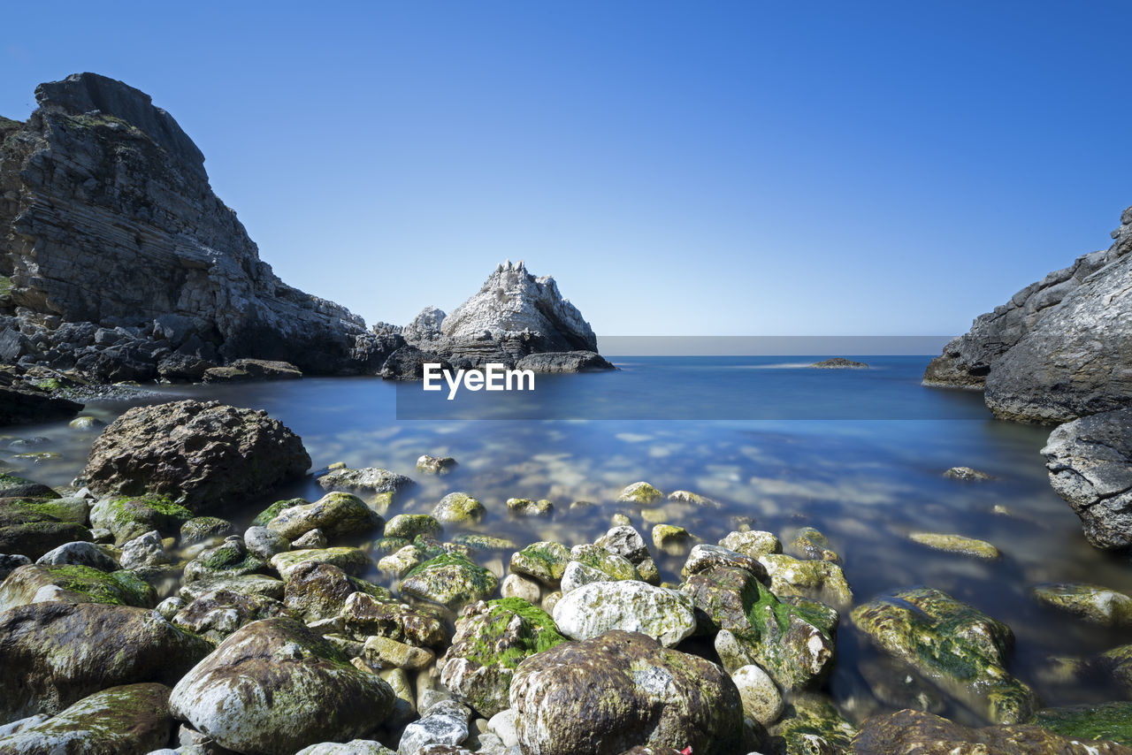 Scenic view of sea against clear blue sky