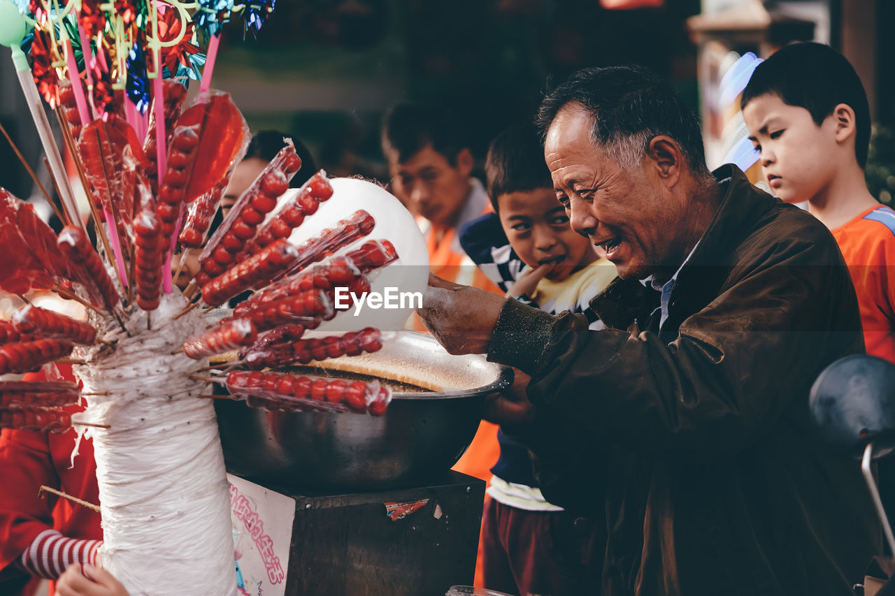 GROUP OF PEOPLE LOOKING AT TRADITIONAL CLOTHING