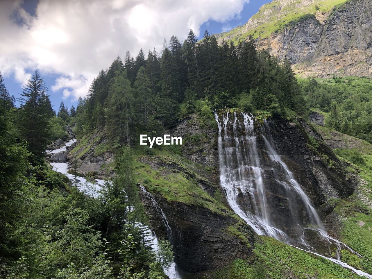 Scenic view of waterfall against sky