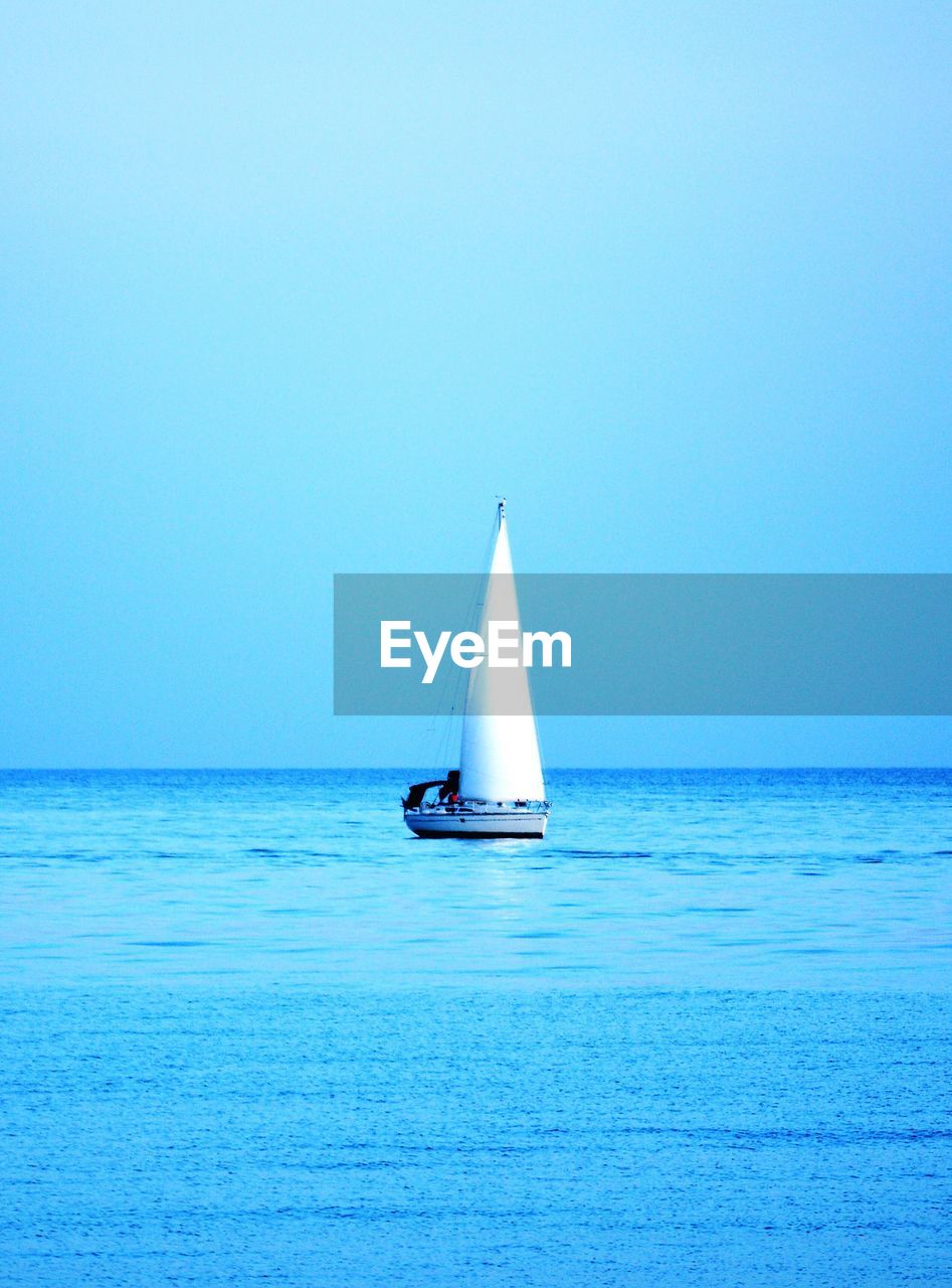 SAILBOAT SAILING IN SEA AGAINST SKY