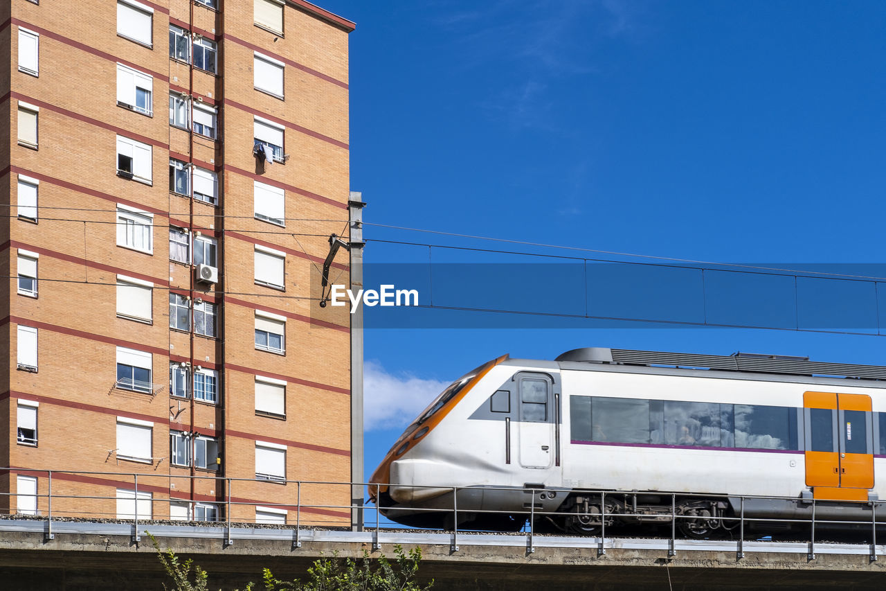 Commuter train on an elevated bridge in an apartment area in the city of hospitalet de llobregat 