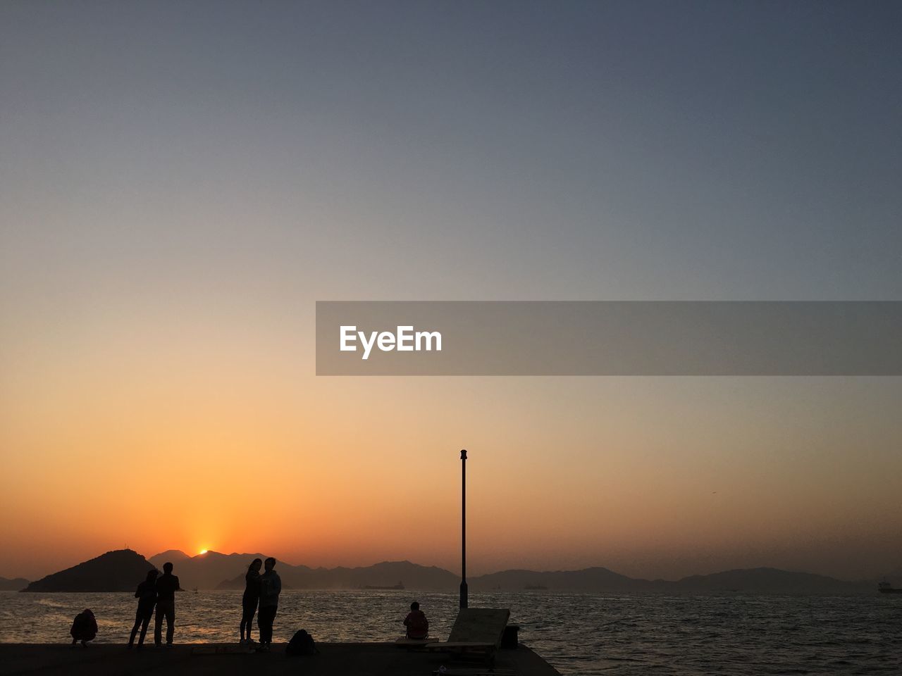 Silhouette of people on beach at sunset