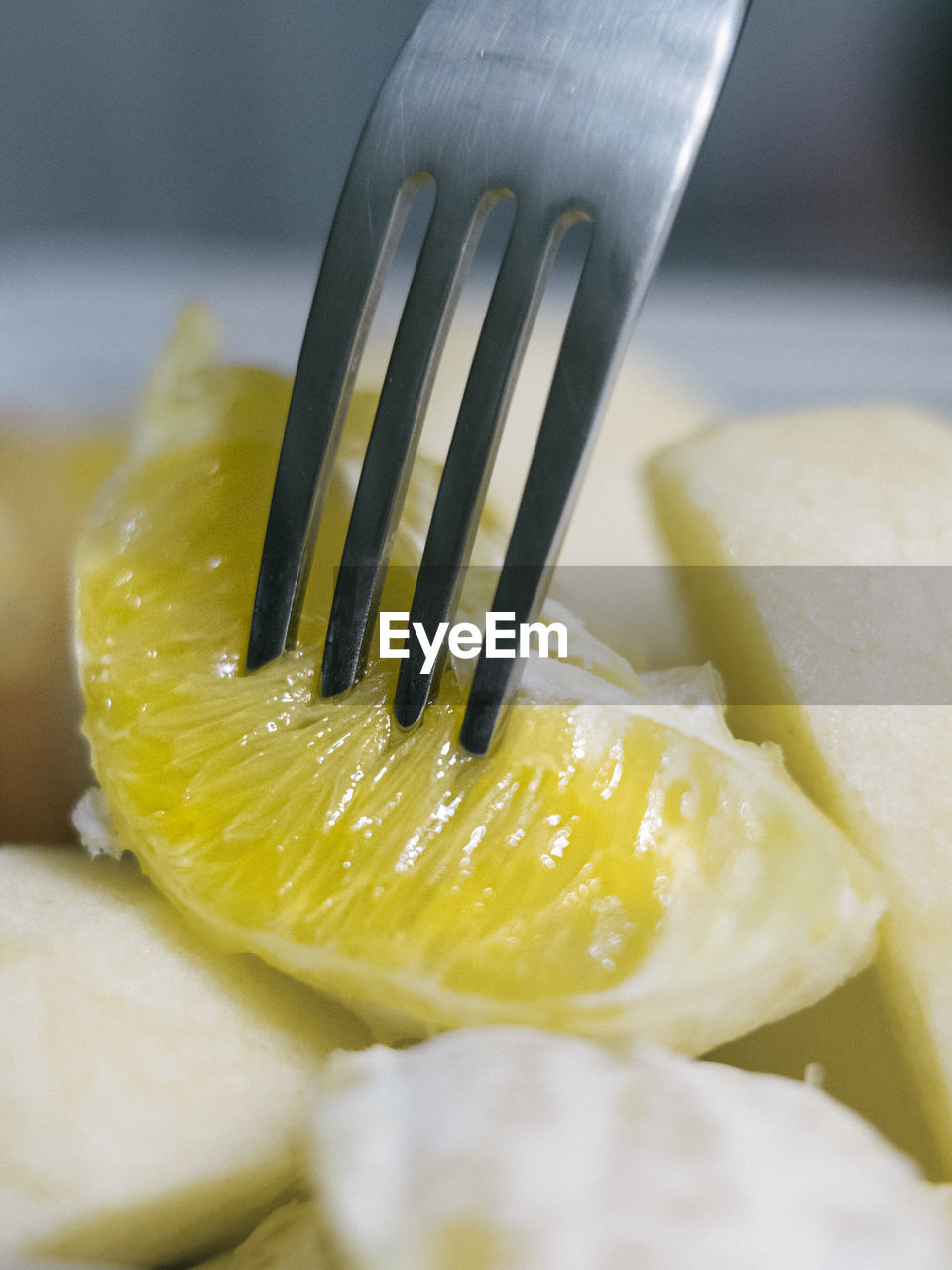 Close up view of fork picking up slice of orange