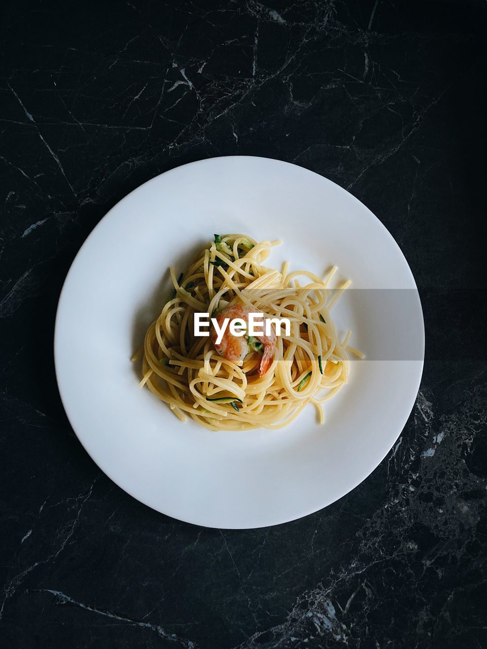 High angle view of spaghetti with shrimps in plate on table