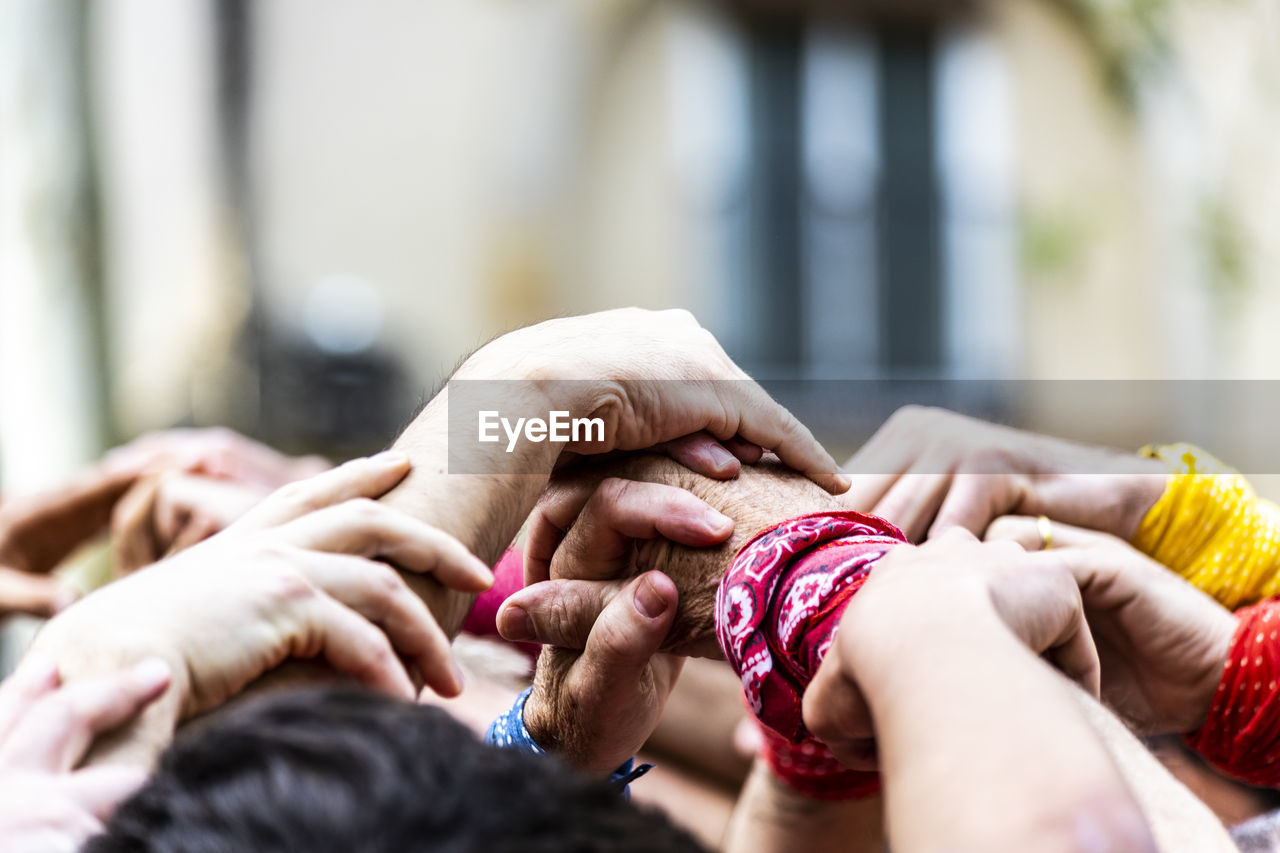 Cropped image of people holding hands outdoors