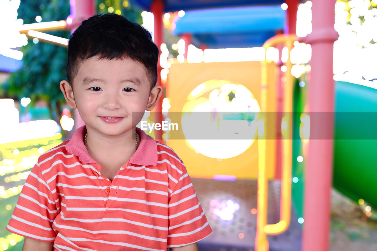 Portrait of cute smiling boy against playground