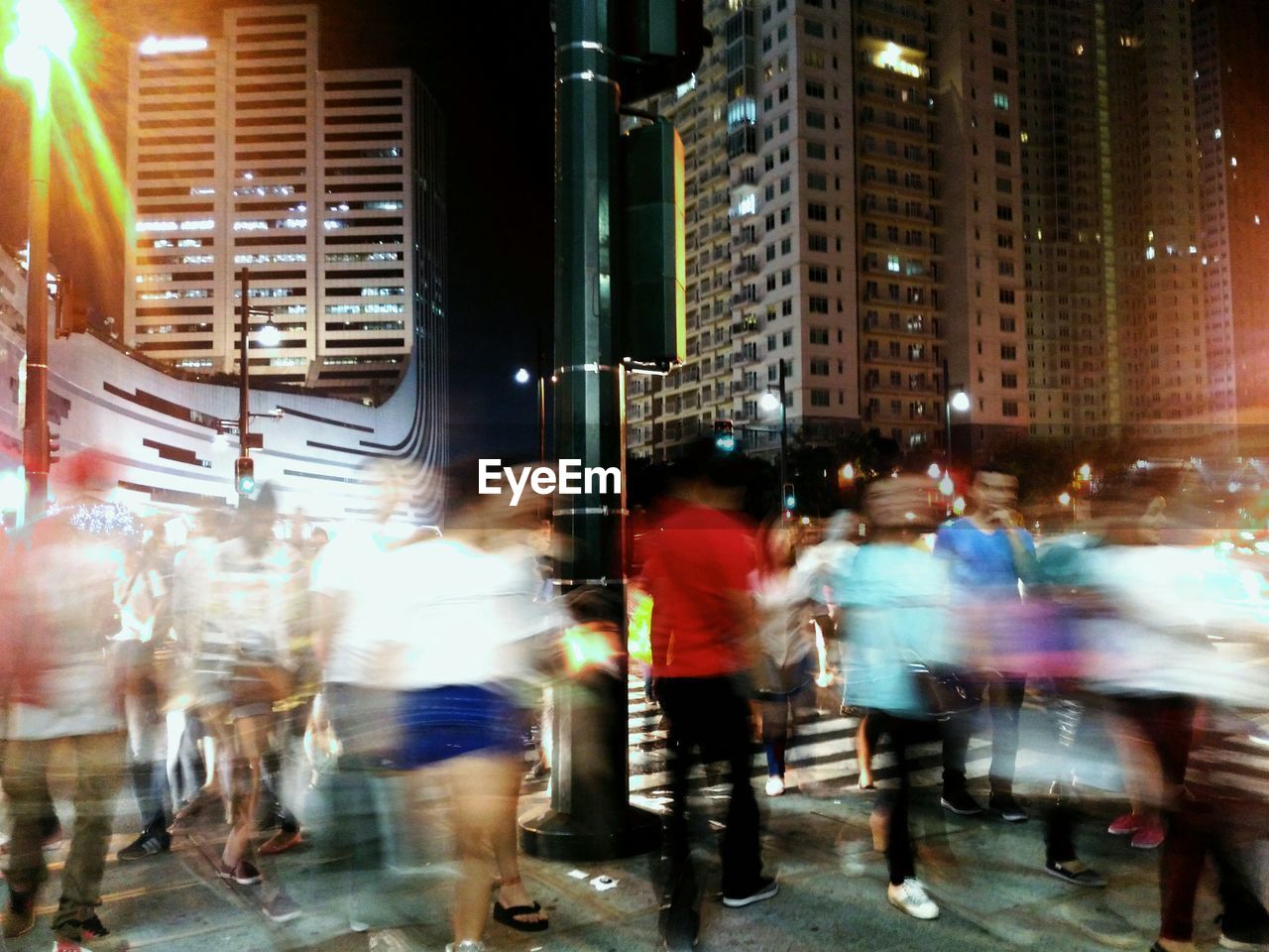 PEOPLE WALKING ON CITY STREET AT NIGHT