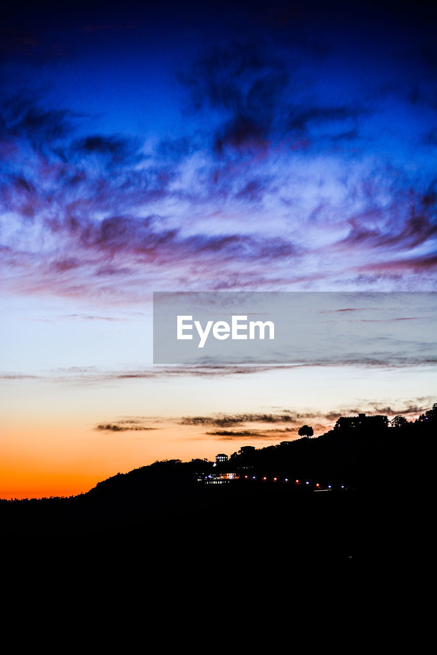 SILHOUETTE LANDSCAPE AGAINST SUNSET SKY