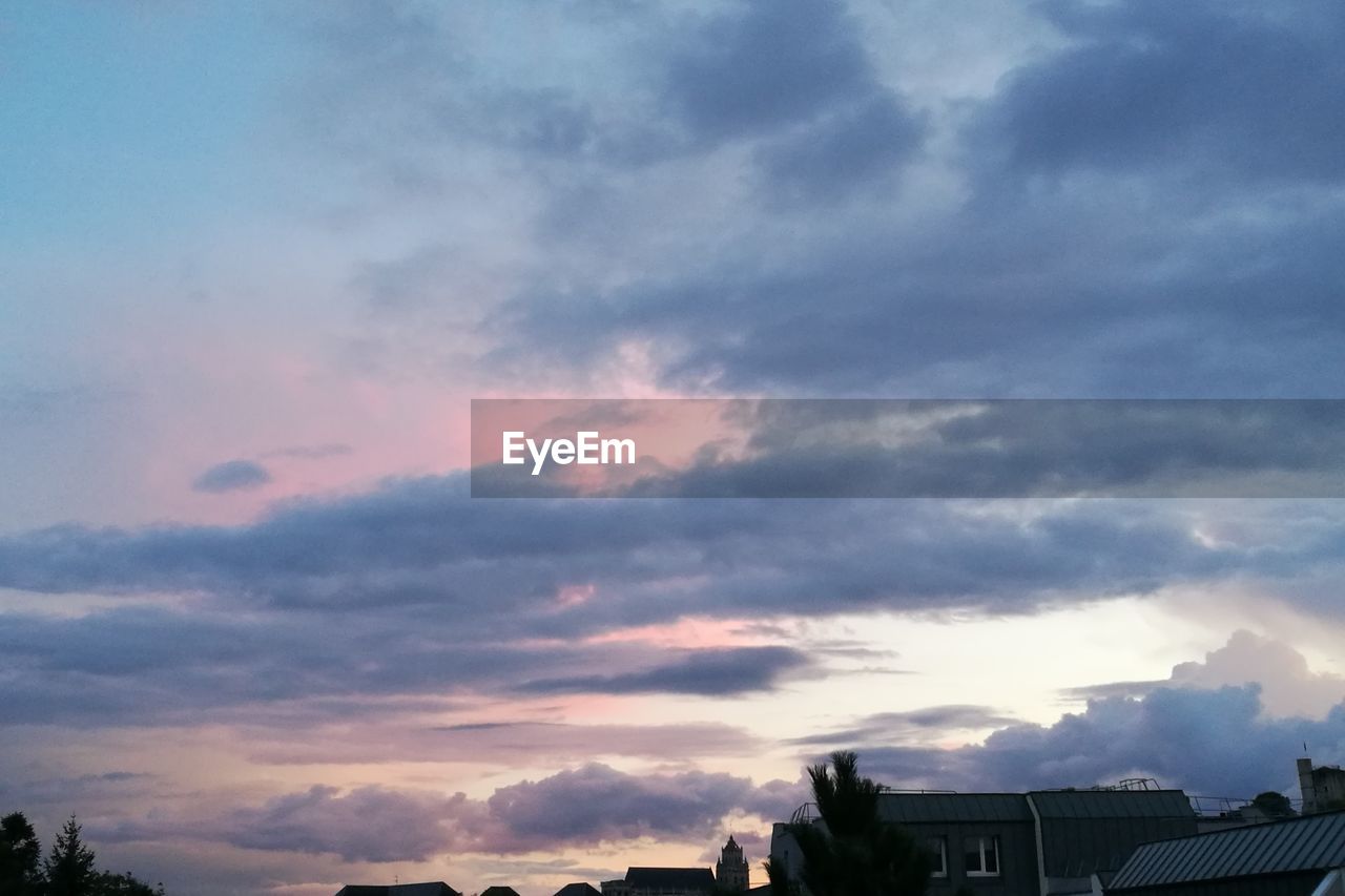 LOW ANGLE VIEW OF DRAMATIC SKY OVER SILHOUETTE BUILDINGS