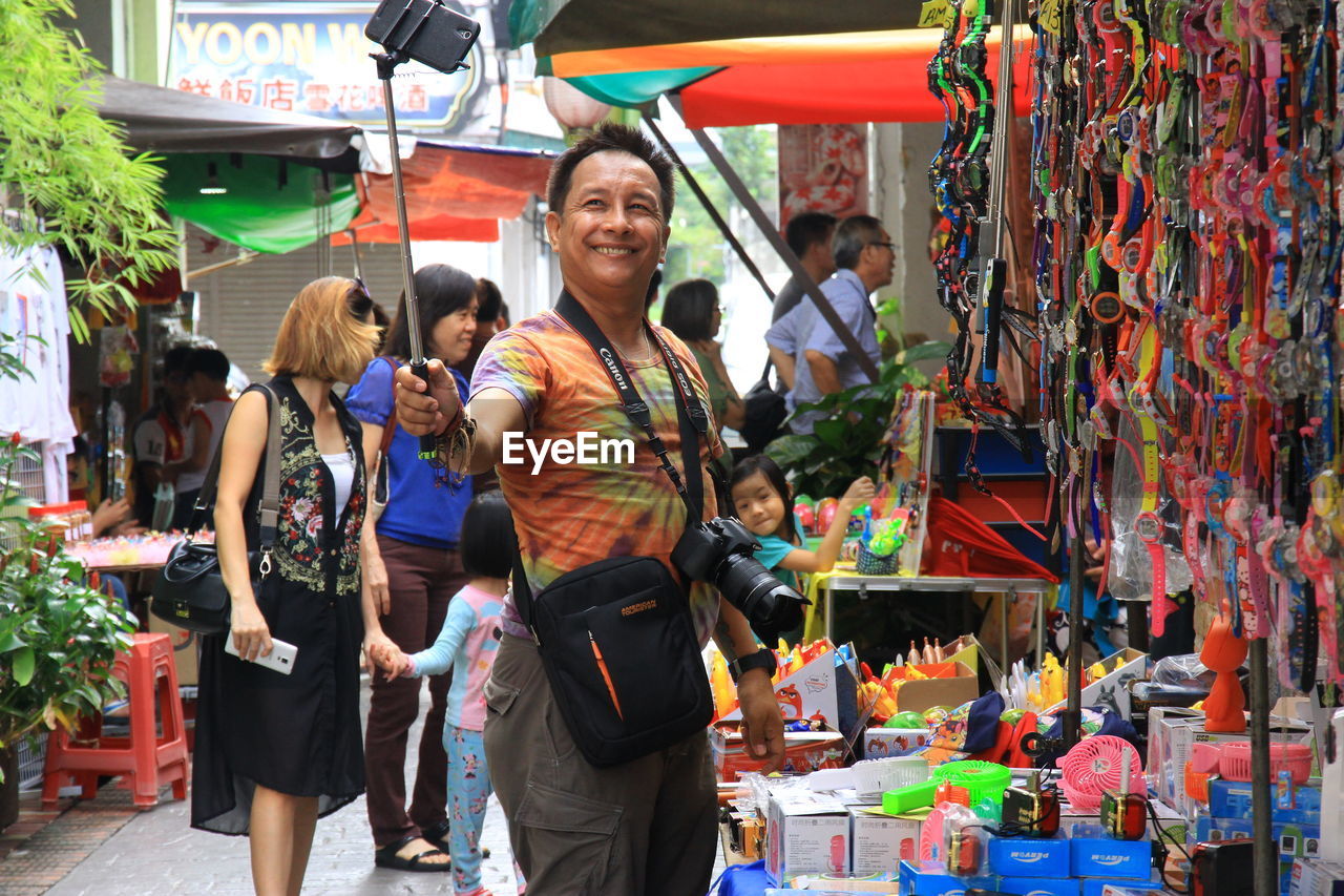 PEOPLE STANDING IN MARKET STALL