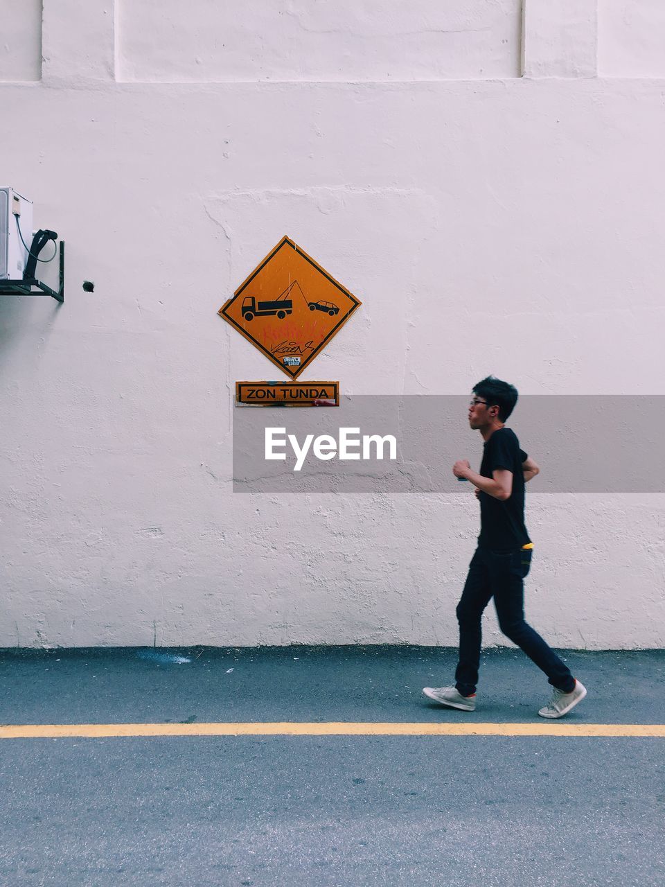 REAR VIEW OF MAN STANDING ON STREET