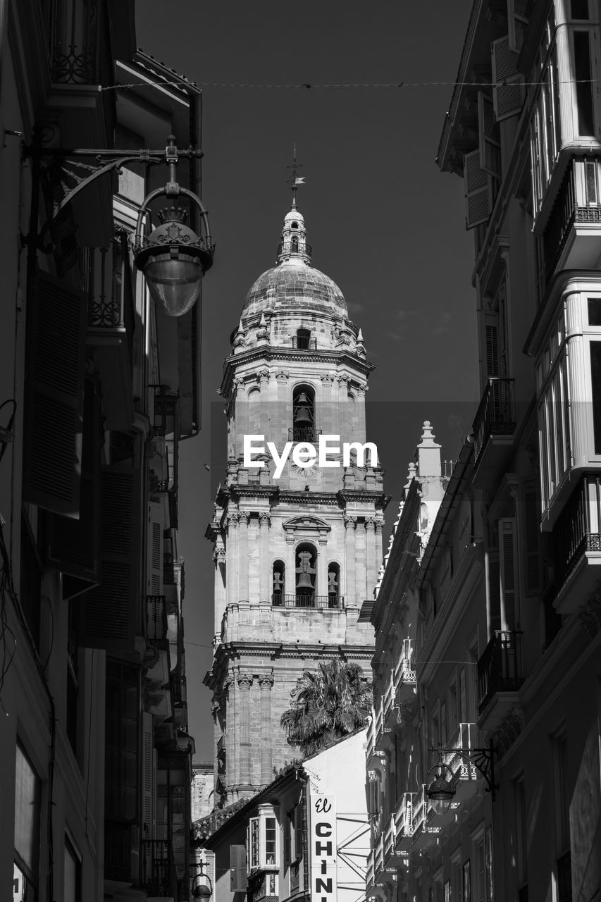 View of malaga cathedral between alleys during the summer..