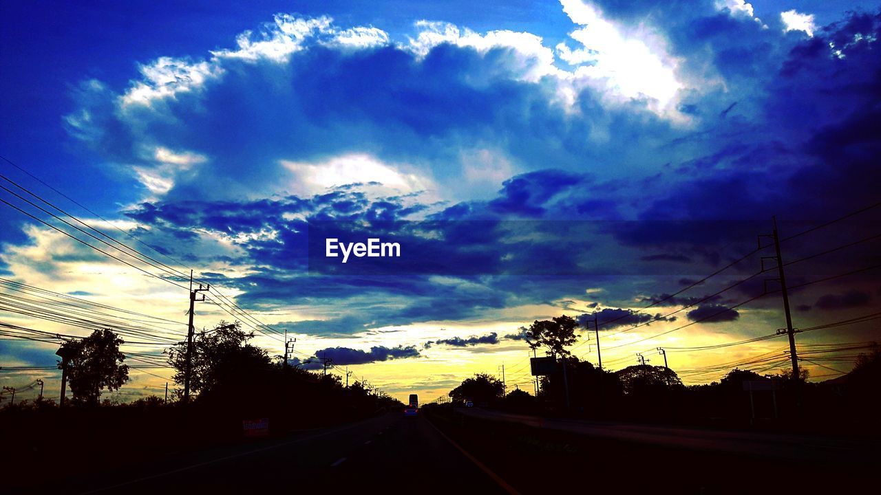 ROAD AGAINST CLOUDY SKY AT SUNSET