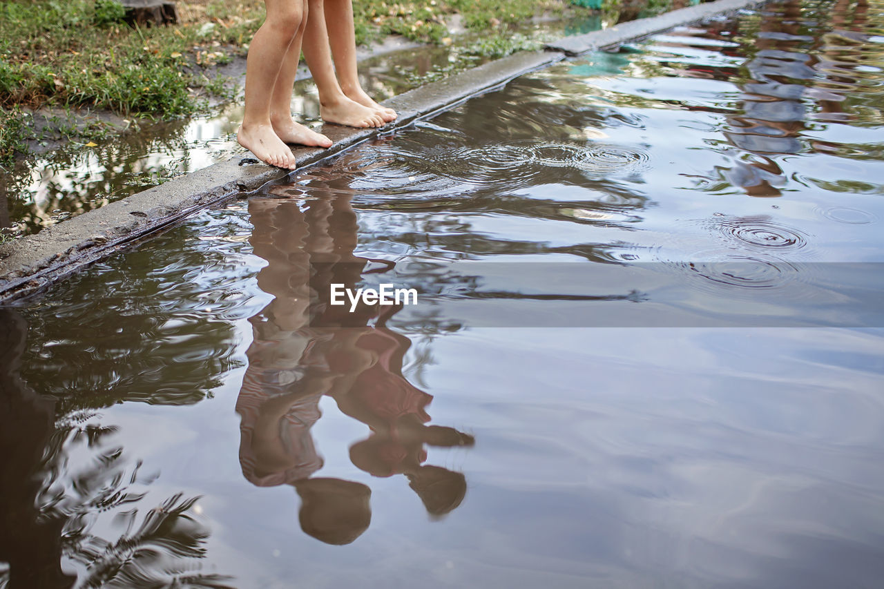 Low section of woman standing in lake