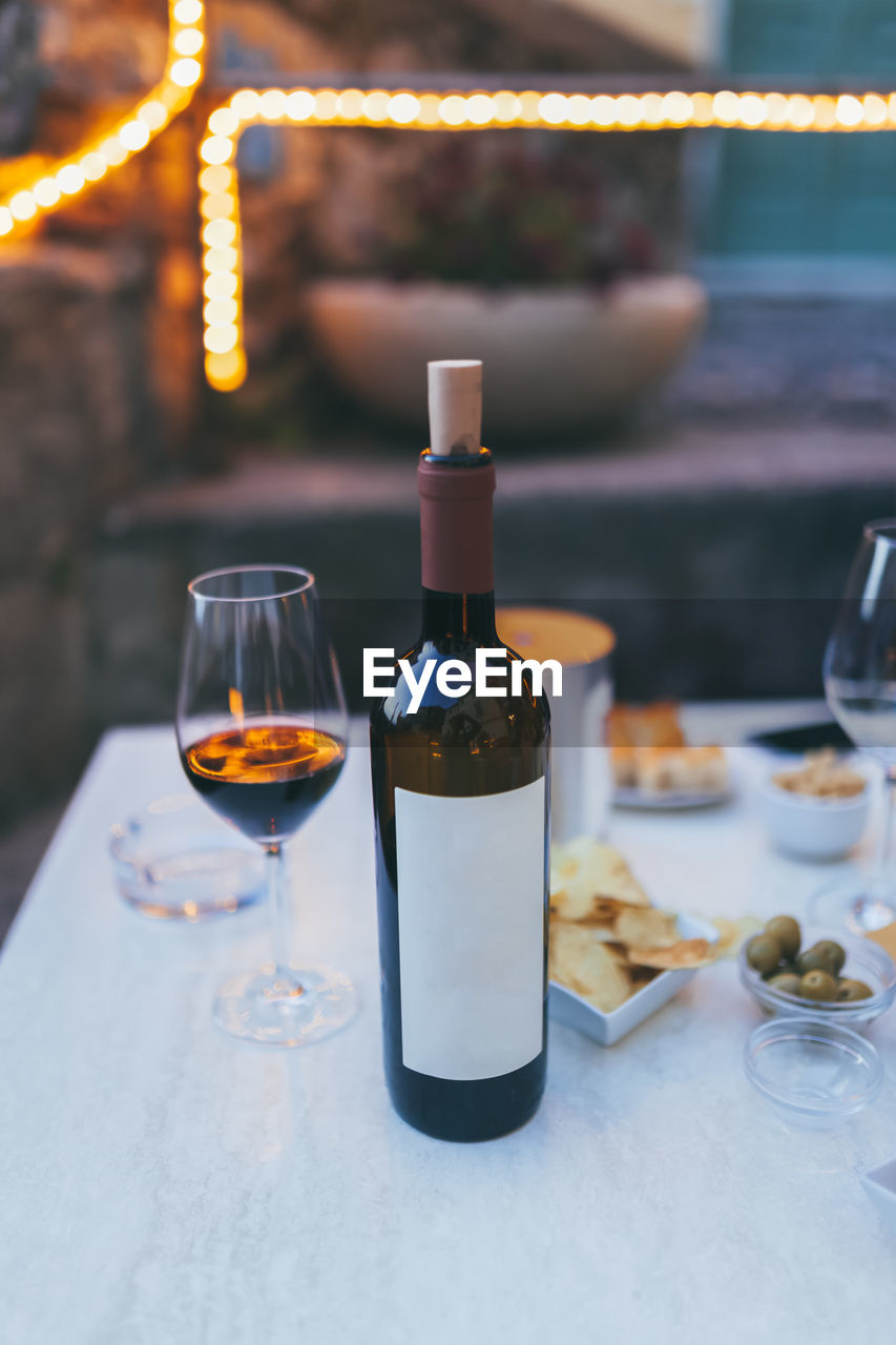 Close-up of wineglass and bottle on table