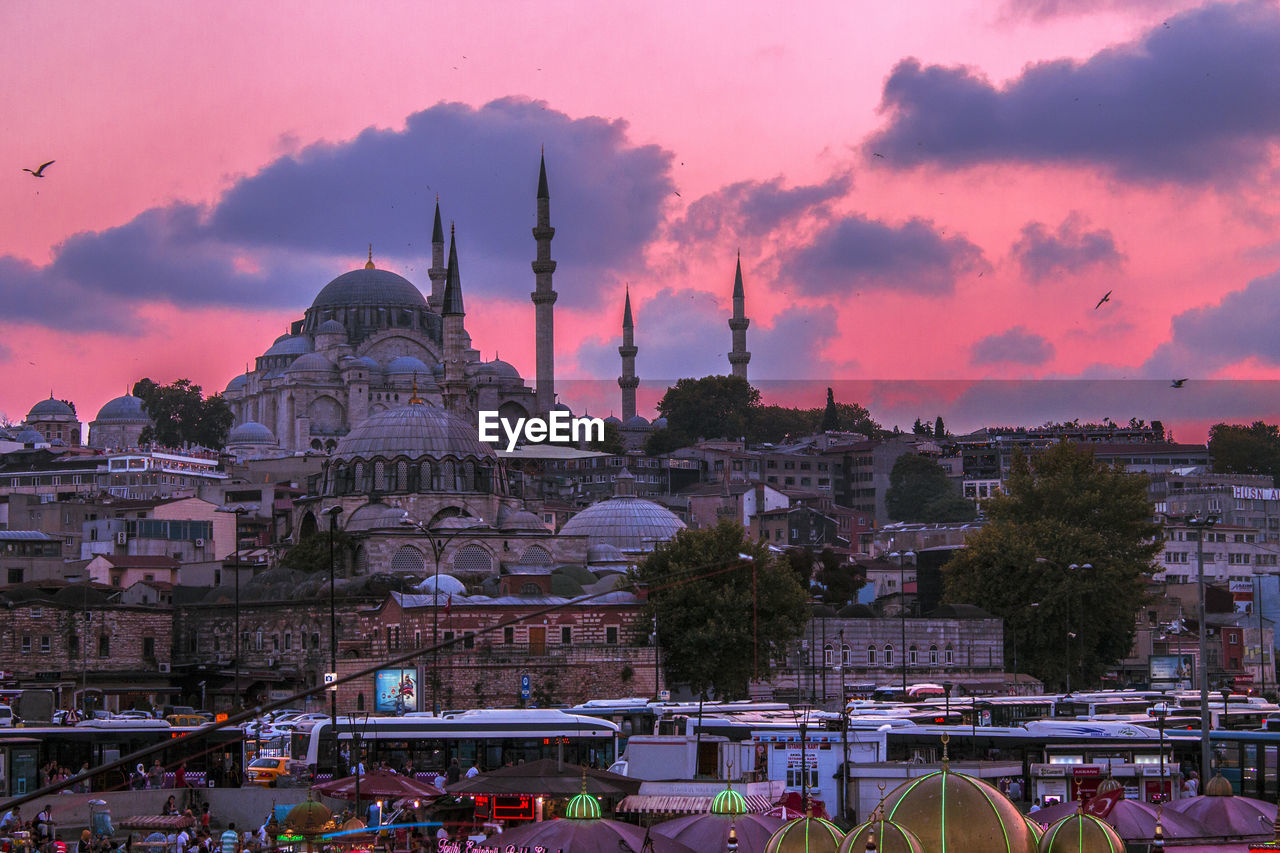 Blue mosque and buildings against cloudy sky