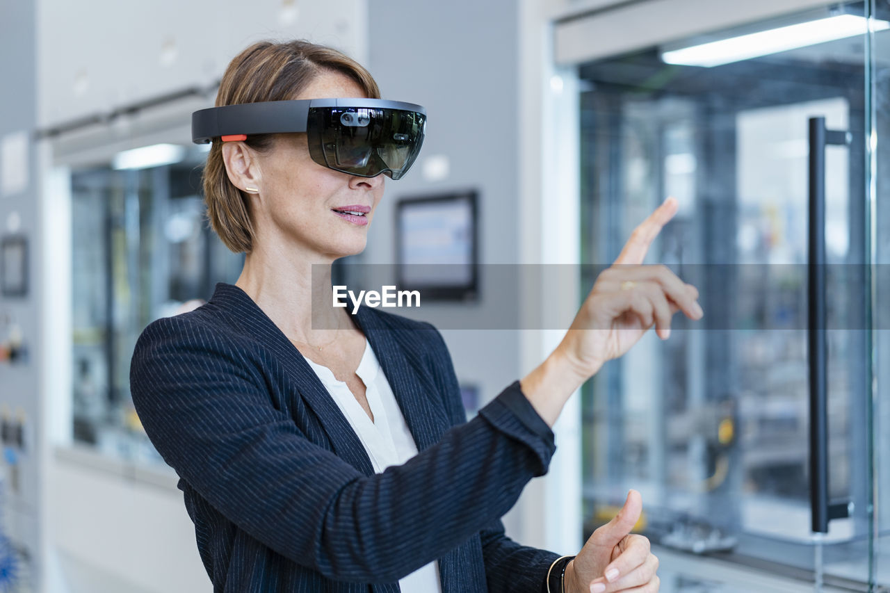 Businesswoman wearing ar glasses in a modern factory