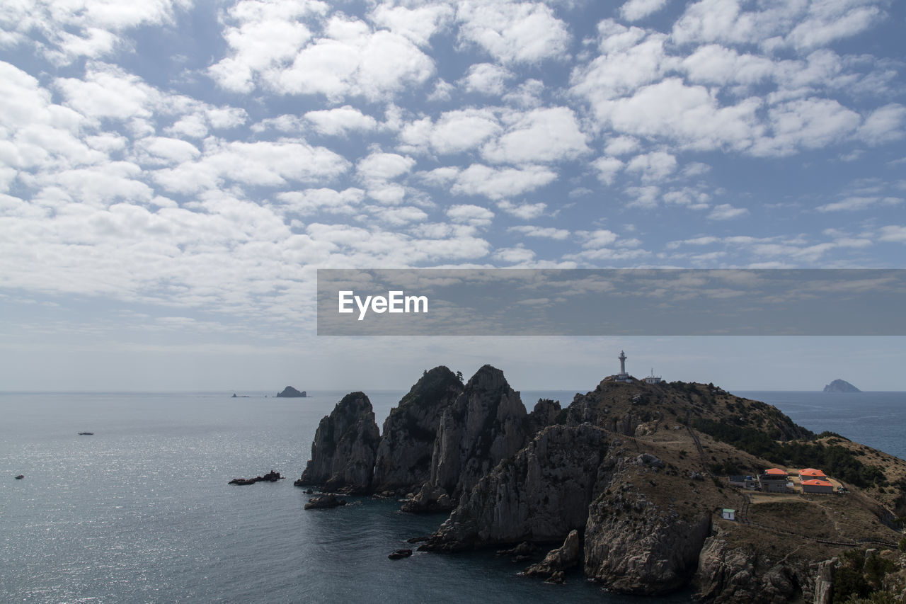 Scenic view of cliff and sea against sky