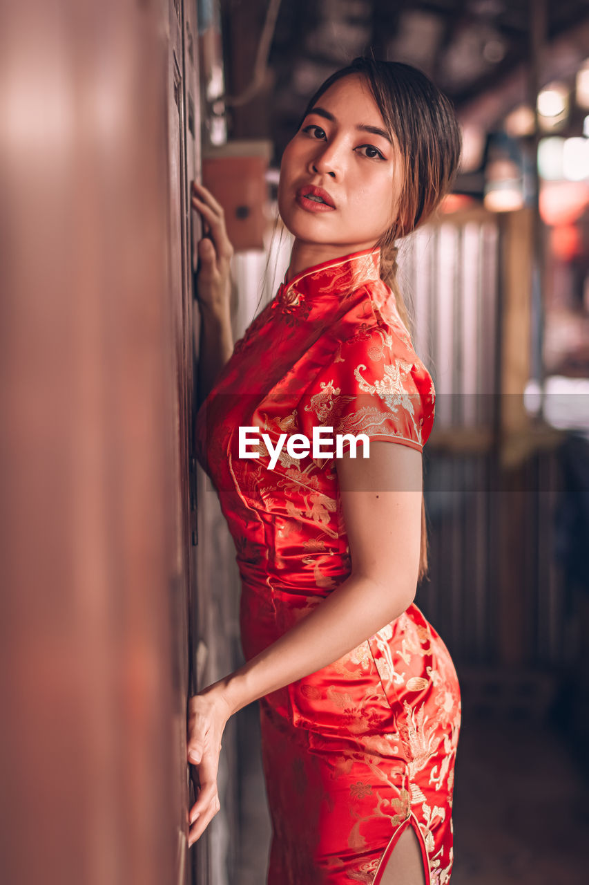 Young woman in traditional clothing against door