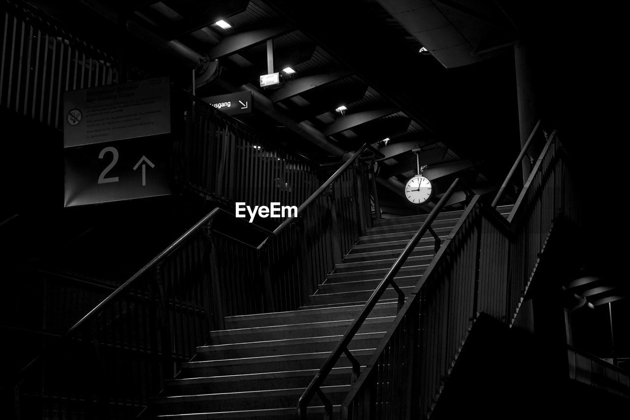 LOW ANGLE VIEW OF ILLUMINATED LIGHTS HANGING ON STAIRCASE