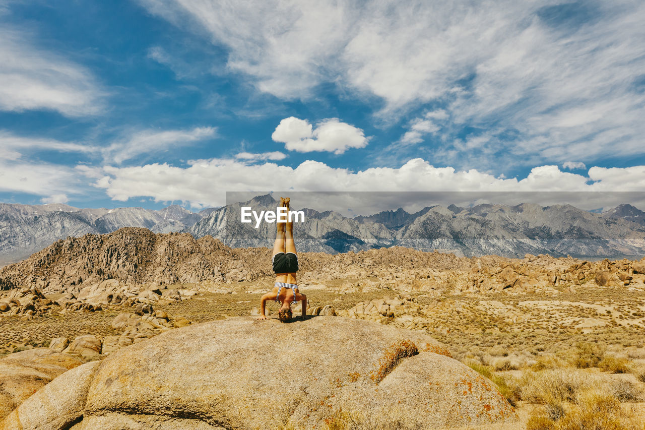 Young woman practicing yoga near alabama hills in northern california.