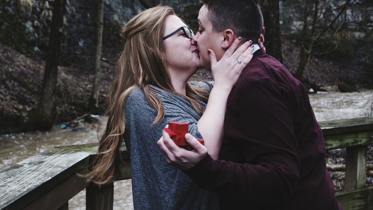 SIDE VIEW OF COUPLE KISSING IN WINTER