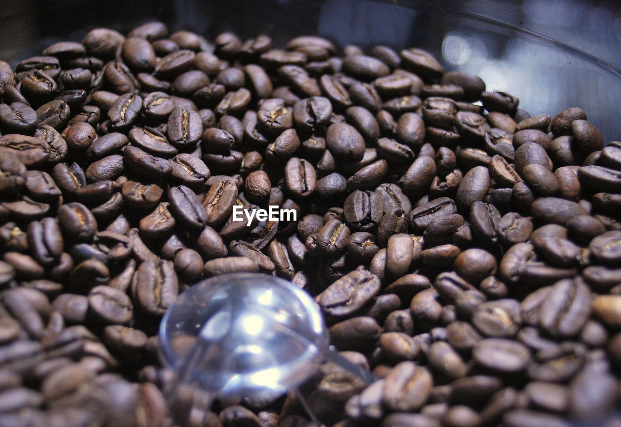 CLOSE-UP OF ROASTED COFFEE BEANS IN BACKGROUND
