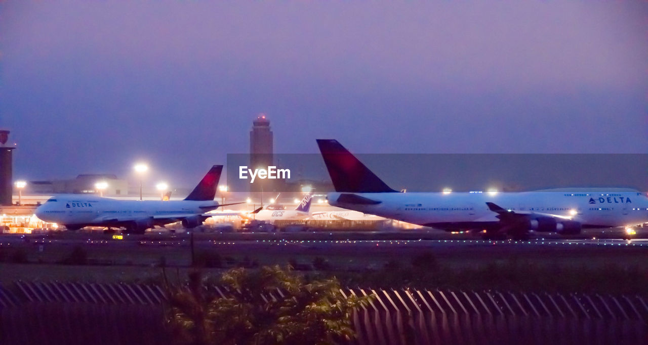 AIRPLANE ON AIRPORT RUNWAY AGAINST SKY