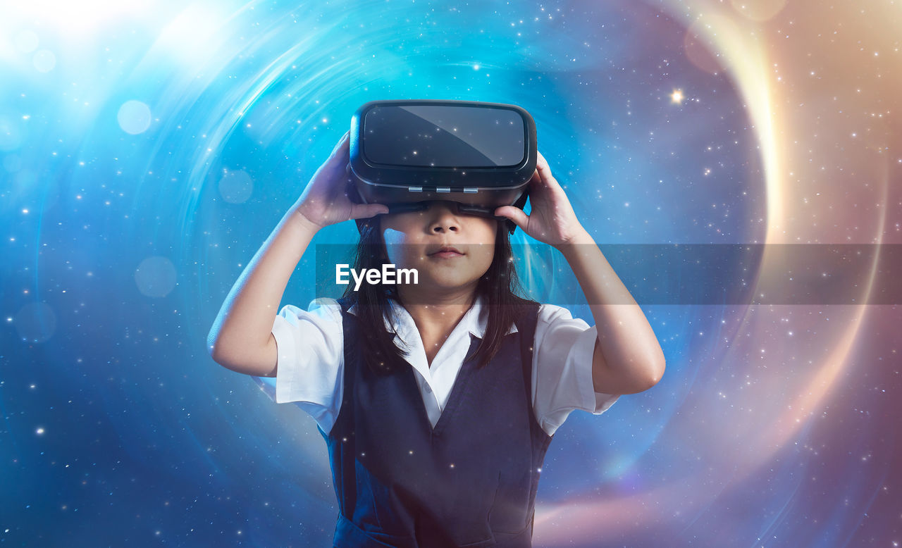 Girl using virtual reality headset against starry background