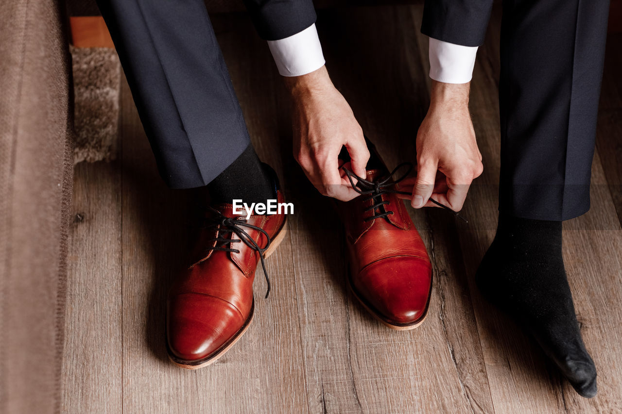 Businessman getting ready for work. putting his shoes on. man puts on his brown shoes.