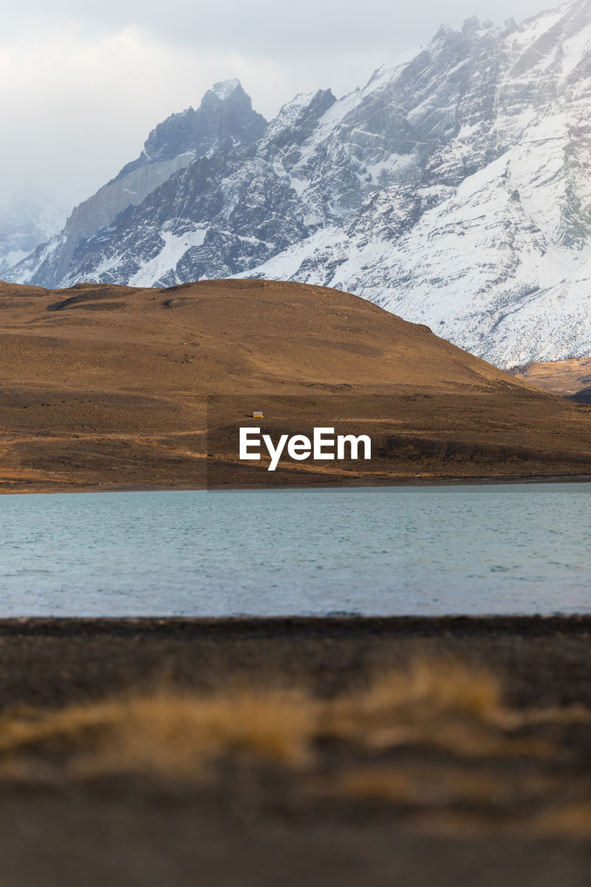 Beautiful scenery of river in valley against foggy snowy mountains