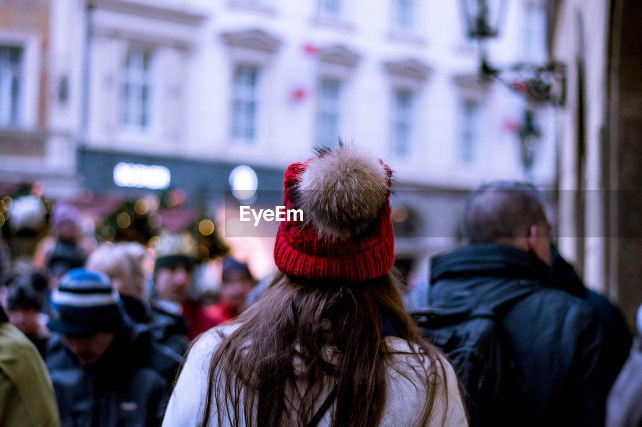 Rear view of woman wearing knit hat against buildings