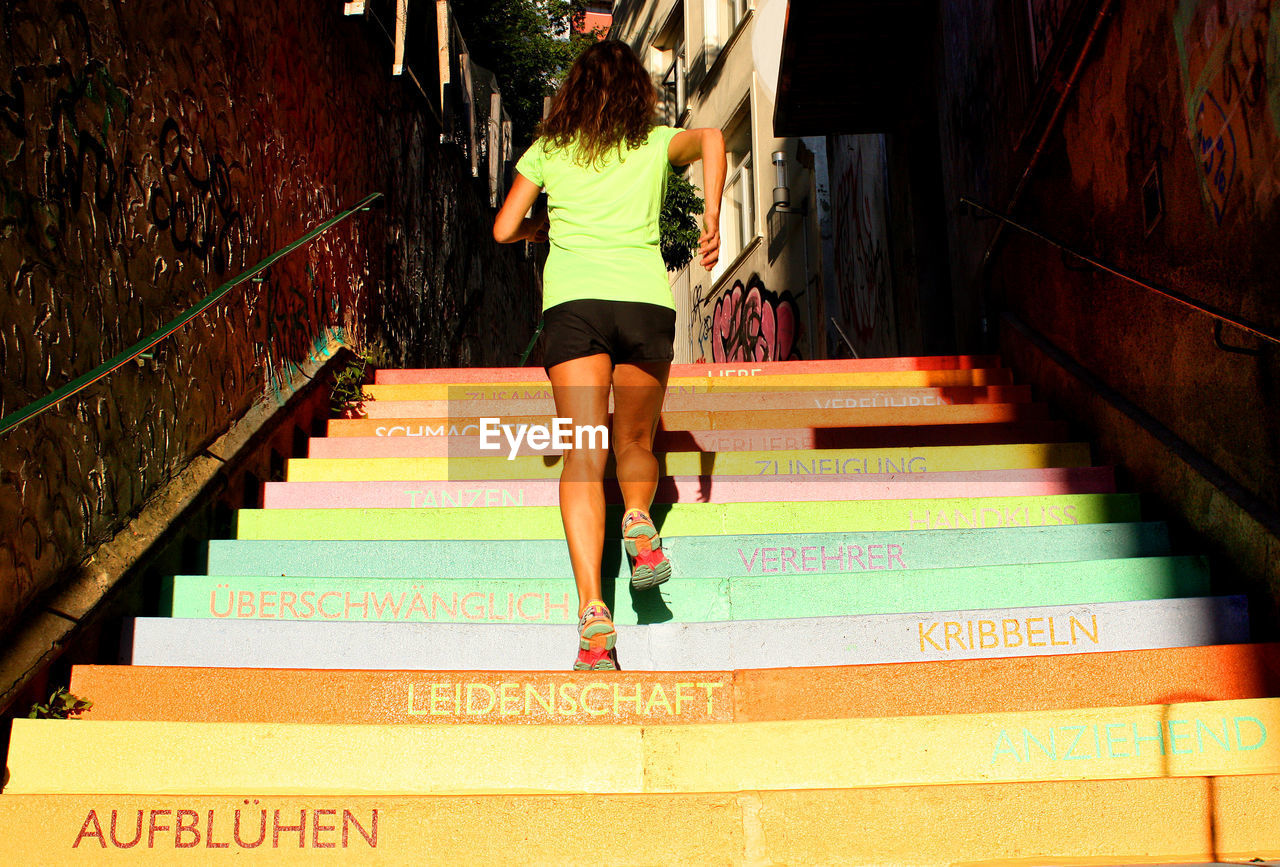 Low angle view of woman climbing steps in city