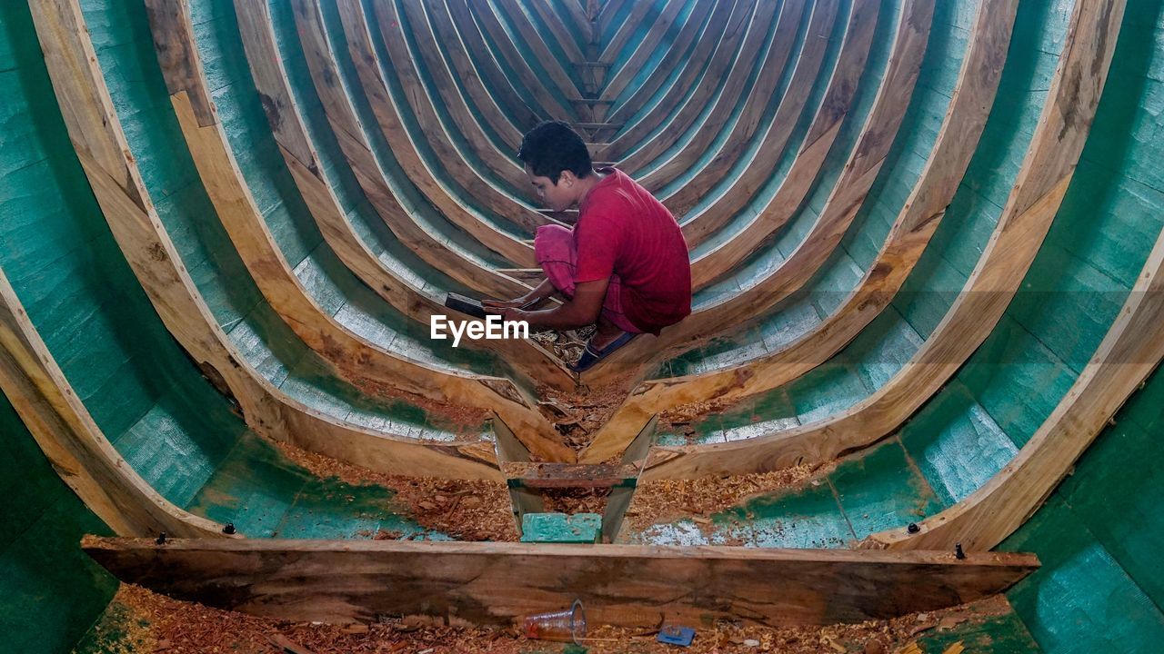 HIGH ANGLE VIEW OF MAN WORKING ON WATER