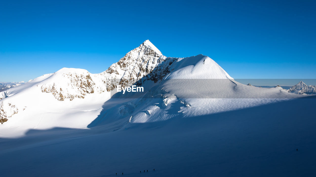 SCENIC VIEW OF SNOWCAPPED MOUNTAINS AGAINST CLEAR BLUE SKY