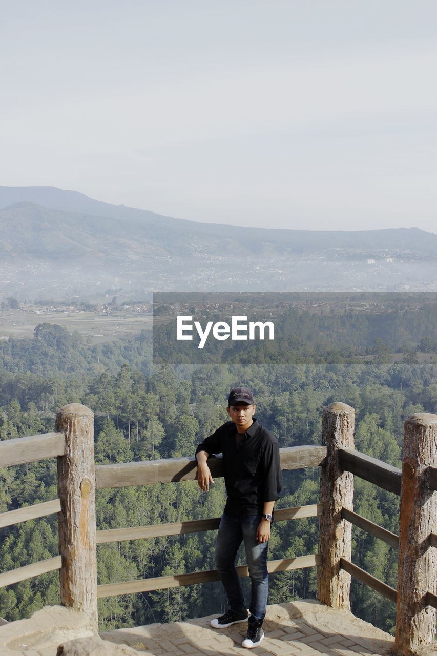 Full length of man standing on mountain against sky