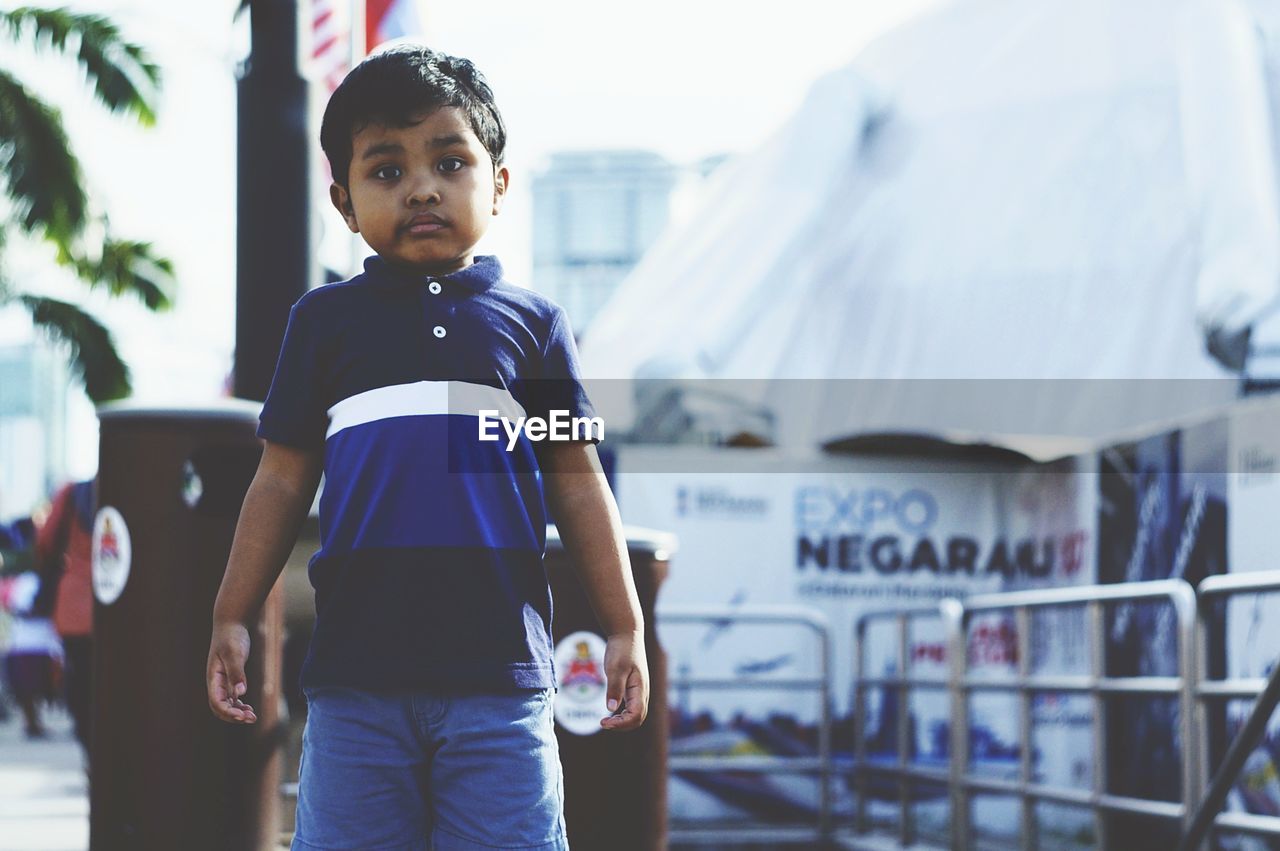 Portrait of boy standing in city