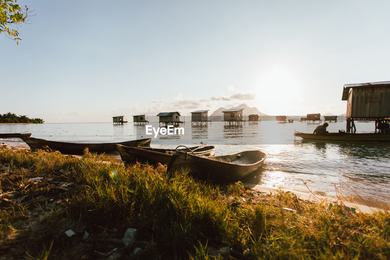 Boats moored at shore against sky