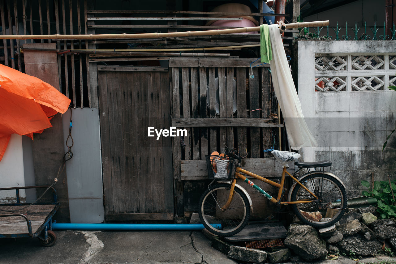 BICYCLE PARKED BY BUILDING