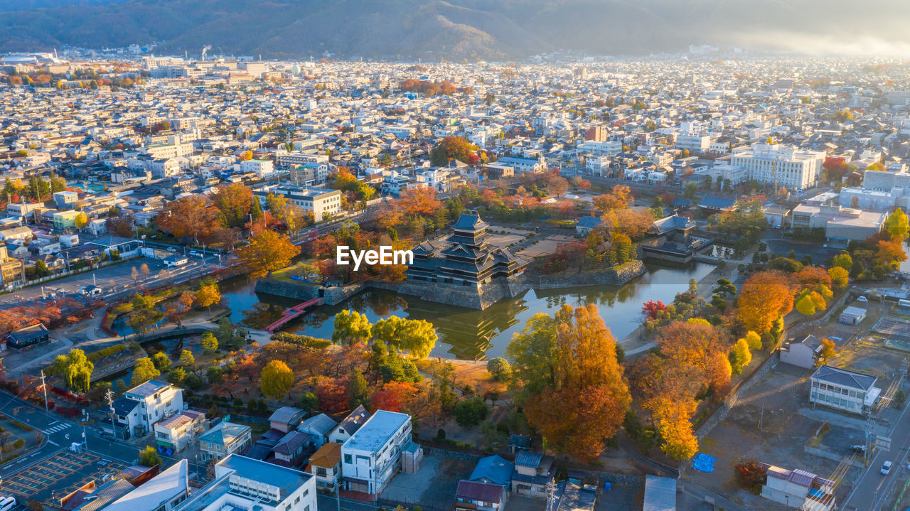 HIGH ANGLE VIEW OF ILLUMINATED CITYSCAPE AGAINST SKY