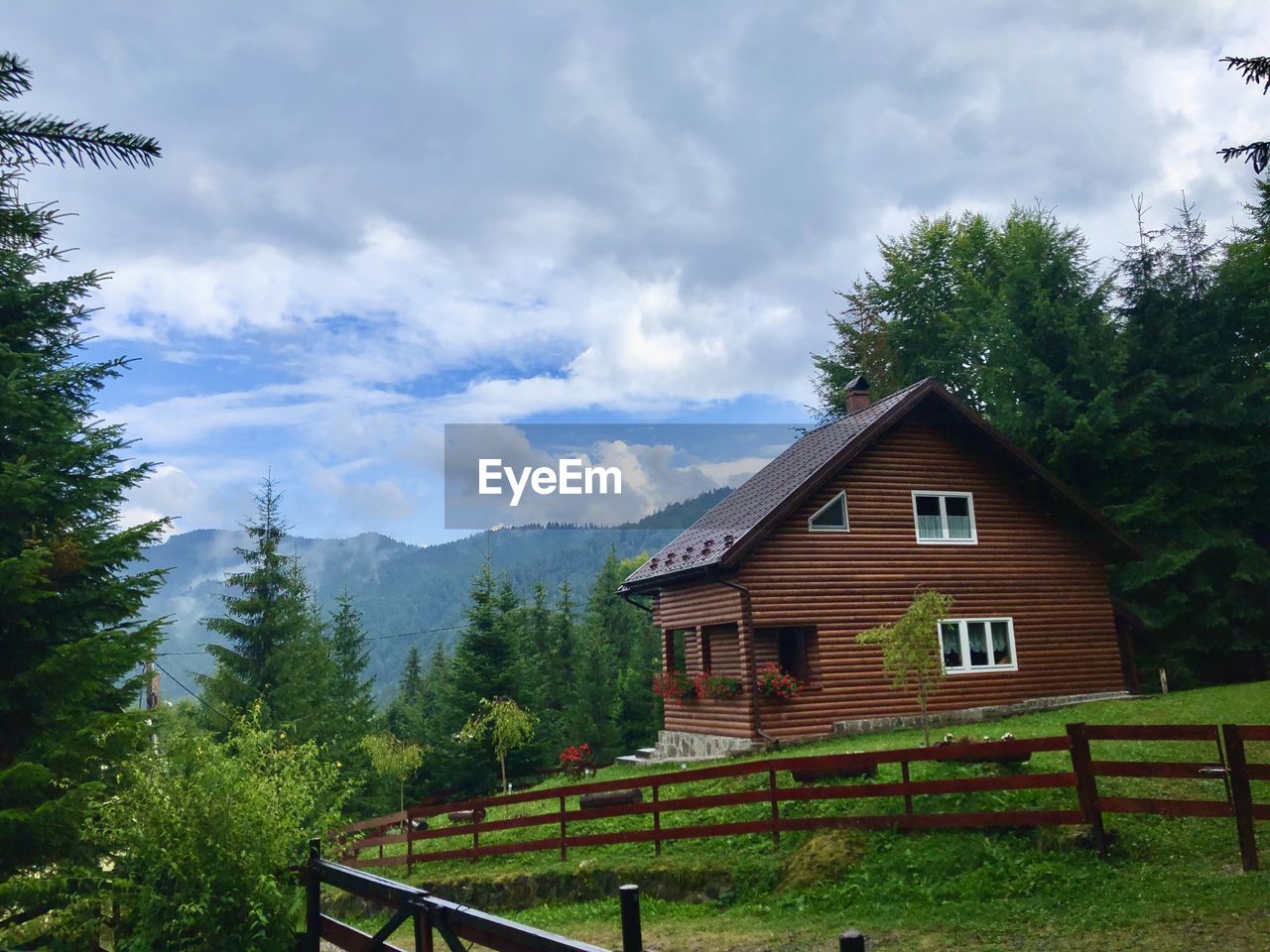 VIEW OF COTTAGE ON MOUNTAIN AGAINST SKY