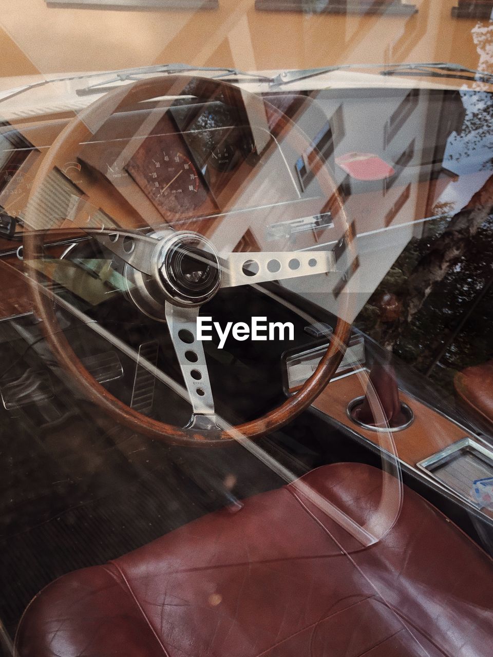 Steering wheel seen through window of vintage car