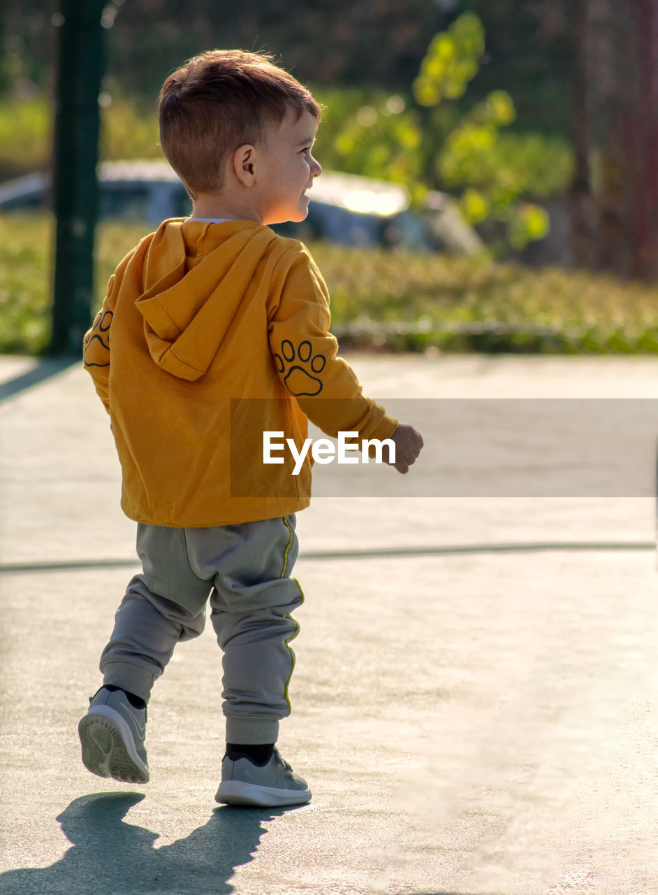 Rear view of boy looking at camera